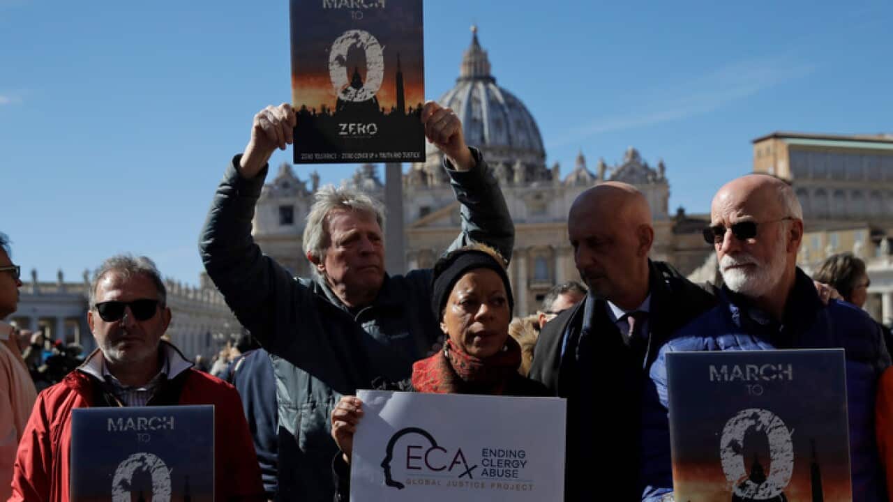 Sex abuse survivors and protestors show banners at the Vatican