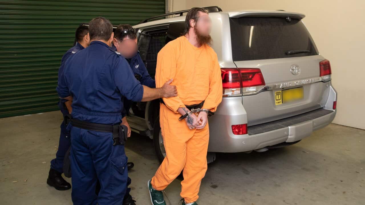 A supplied image obtained Friday, February 19, 2021 of Australian Federal Police arresting a man with planning terrorist attacks in NSW. A NSW prisoner has been charged with planning terrorist attacks from his Goulburn jail cell. (AAP Image/AFP)