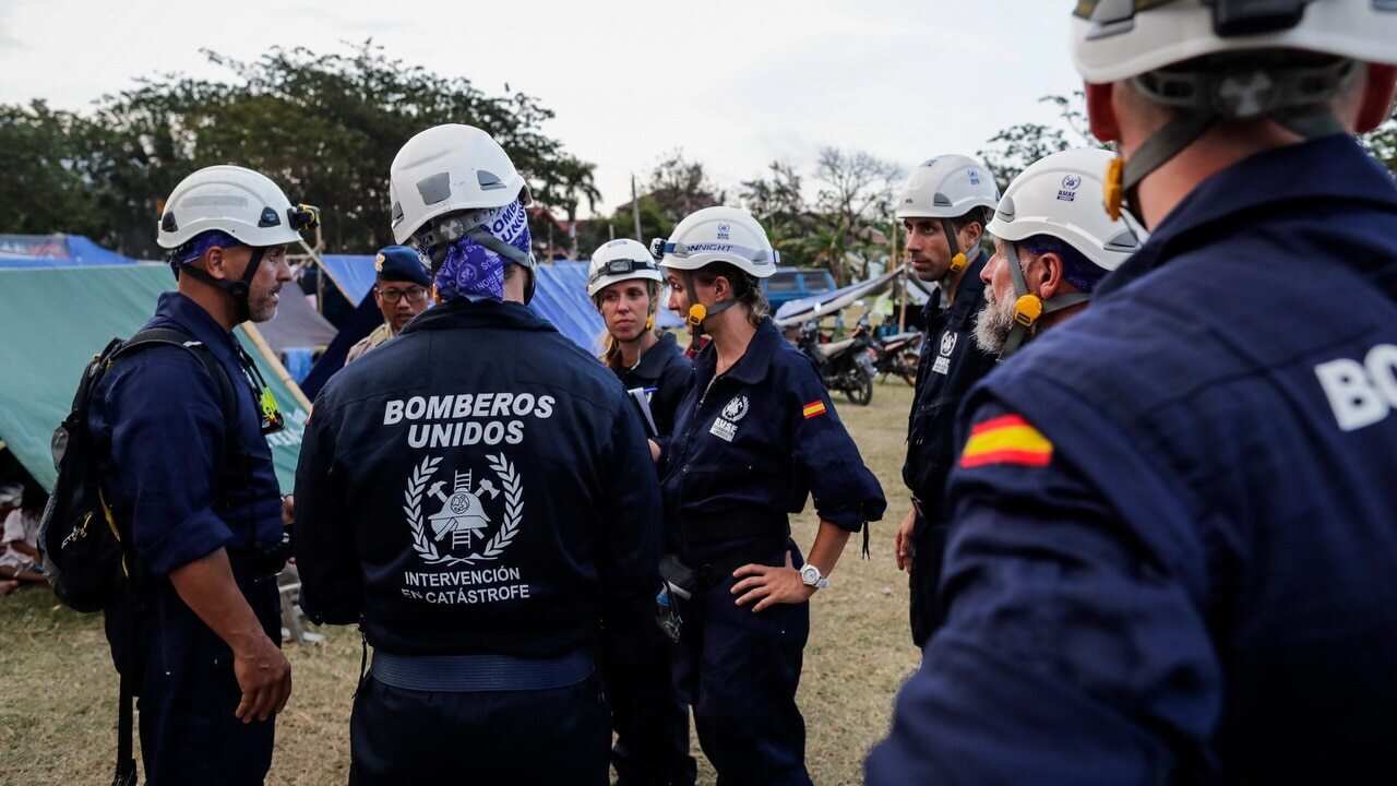 Spanish rescue team members inspect a temporary shelter for earthquake and tsunami survivors outside the grand mosque in Palu.