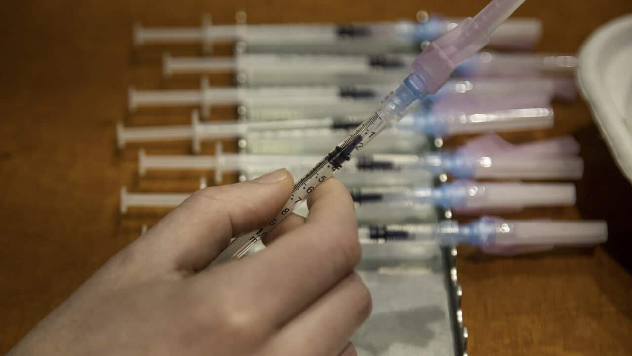 A health worker prepares to administer a Covid-19 booster