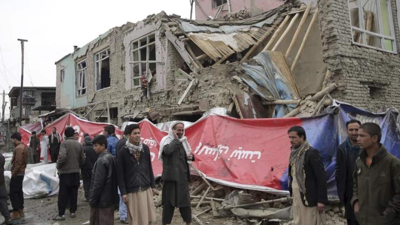 Residents walk though the site of a suicide attack in Kabul.