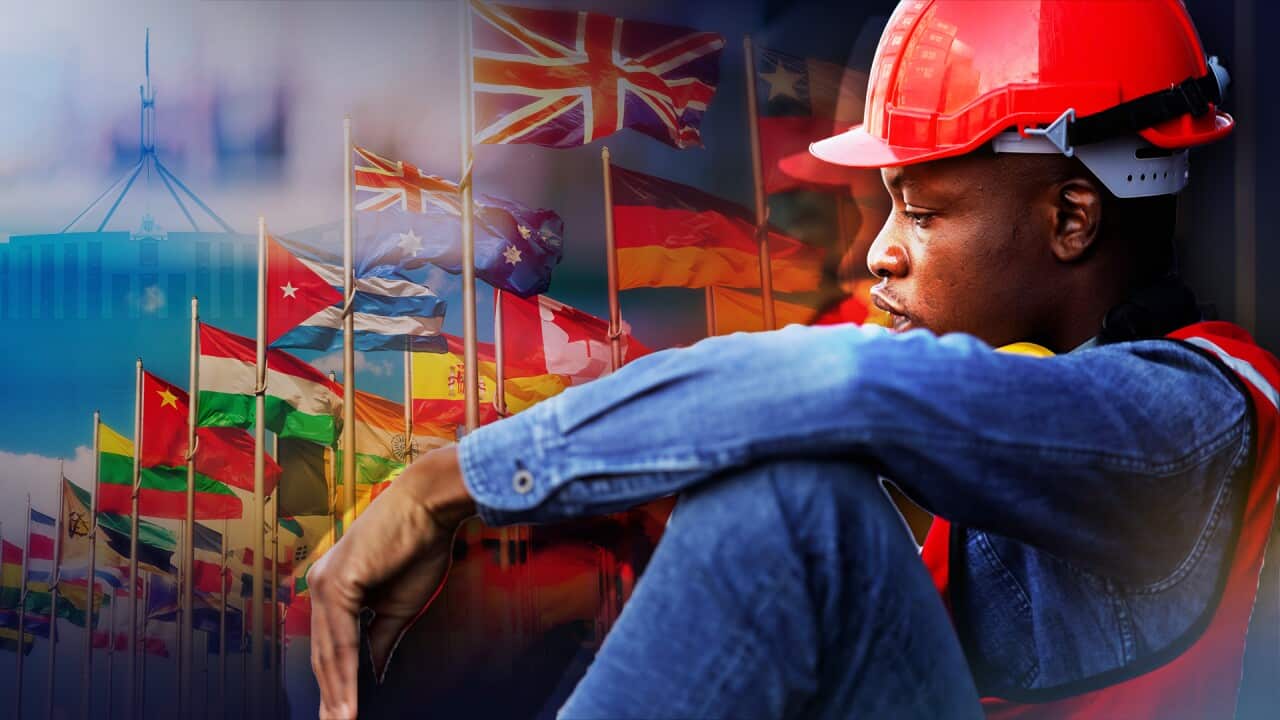 Digital artwork of worker sitting in front of international flags