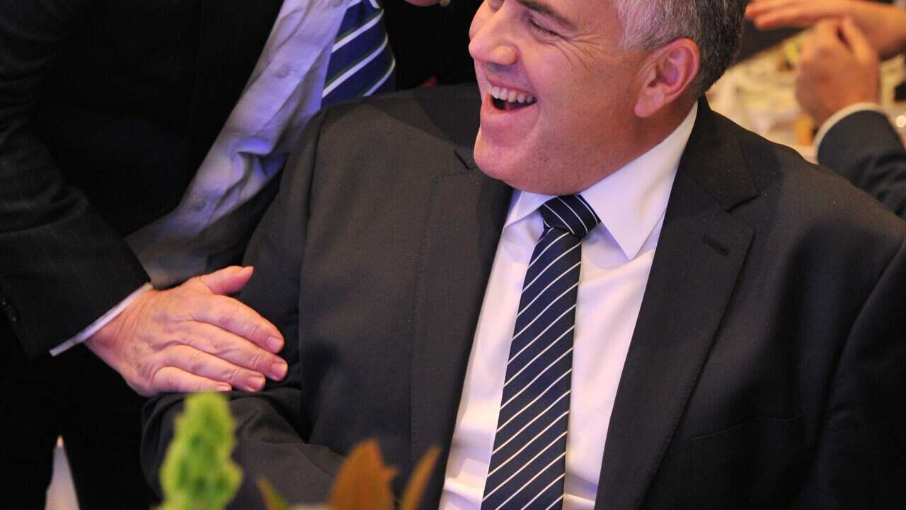 Former Federal Treasurer Peter Costello (L) speaks with current federal Treasurer Joe Hockey at a luncheon in Melbourne, Friday, Sept. 5, 2014.