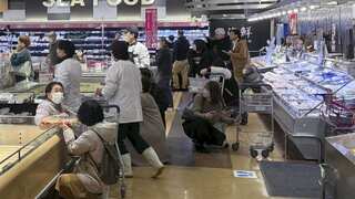 Customers crouch following an earthquake at a supermarket in Toyama, Japan (AAP)