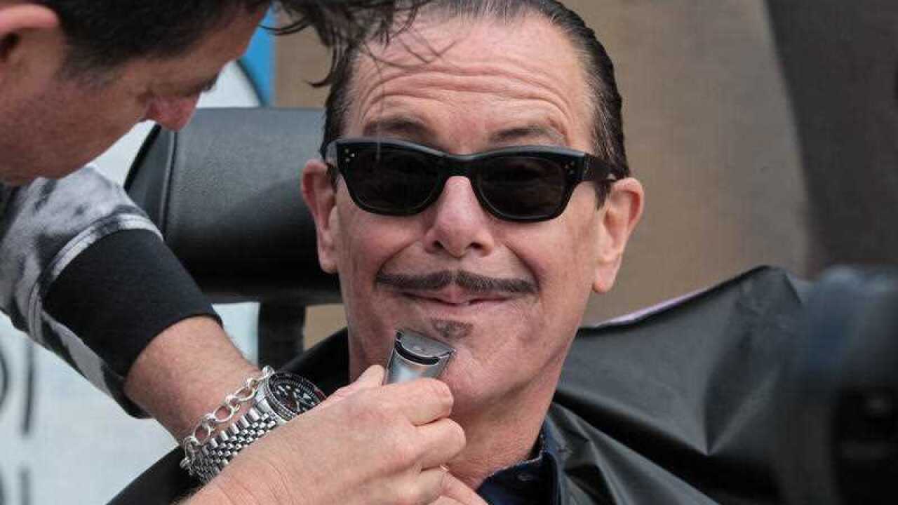 INXS musician Kirk Pengilly, a prostate cancer survivor, has his signature moustache shaved to prepare for the start of Movember, at Bondi Beach, Sydney