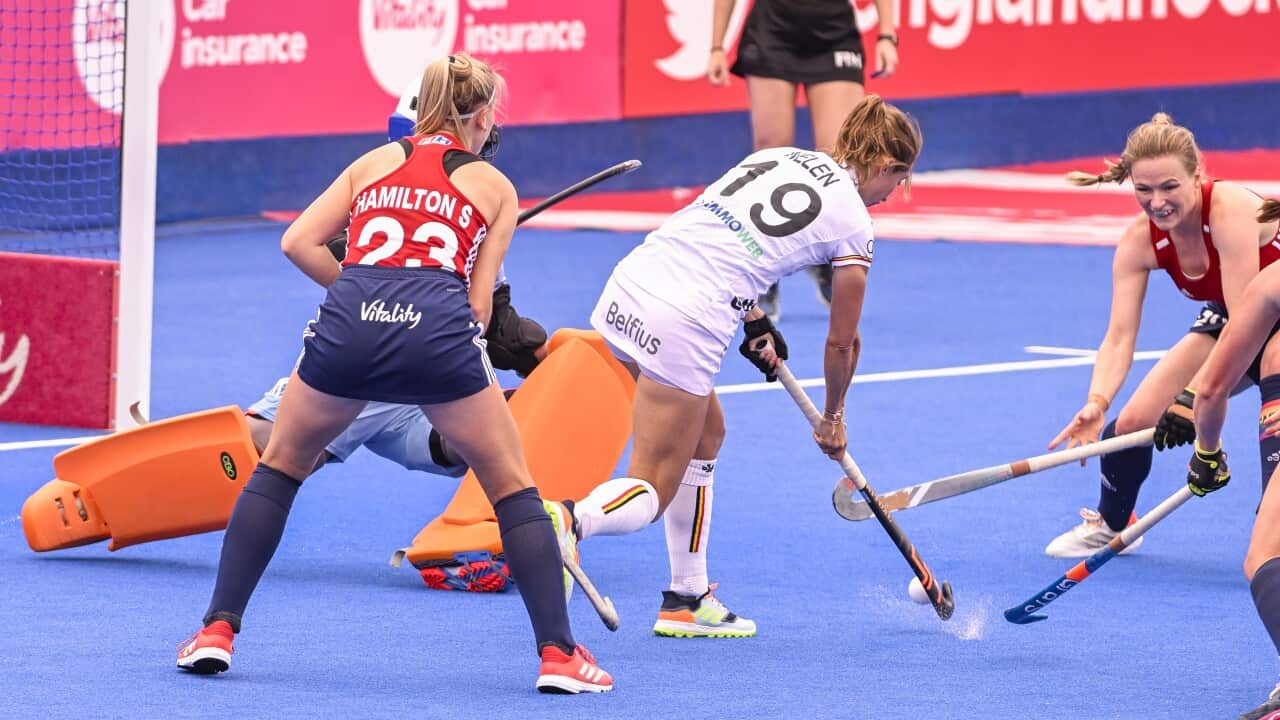 Two female hockey players fight for the ball during a match between England and the Belgian Red Panthers
