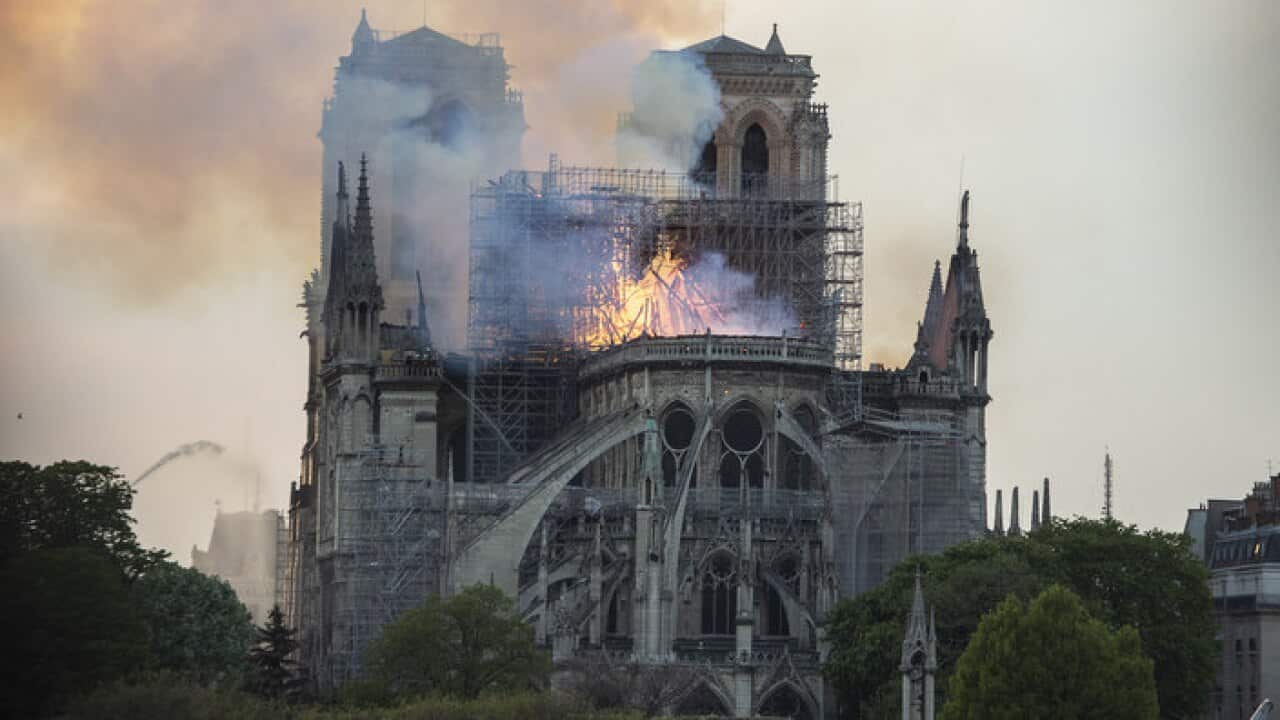 Smoke and flames rise during a fire at the landmark Notre-Dame Cathedral in central Paris
