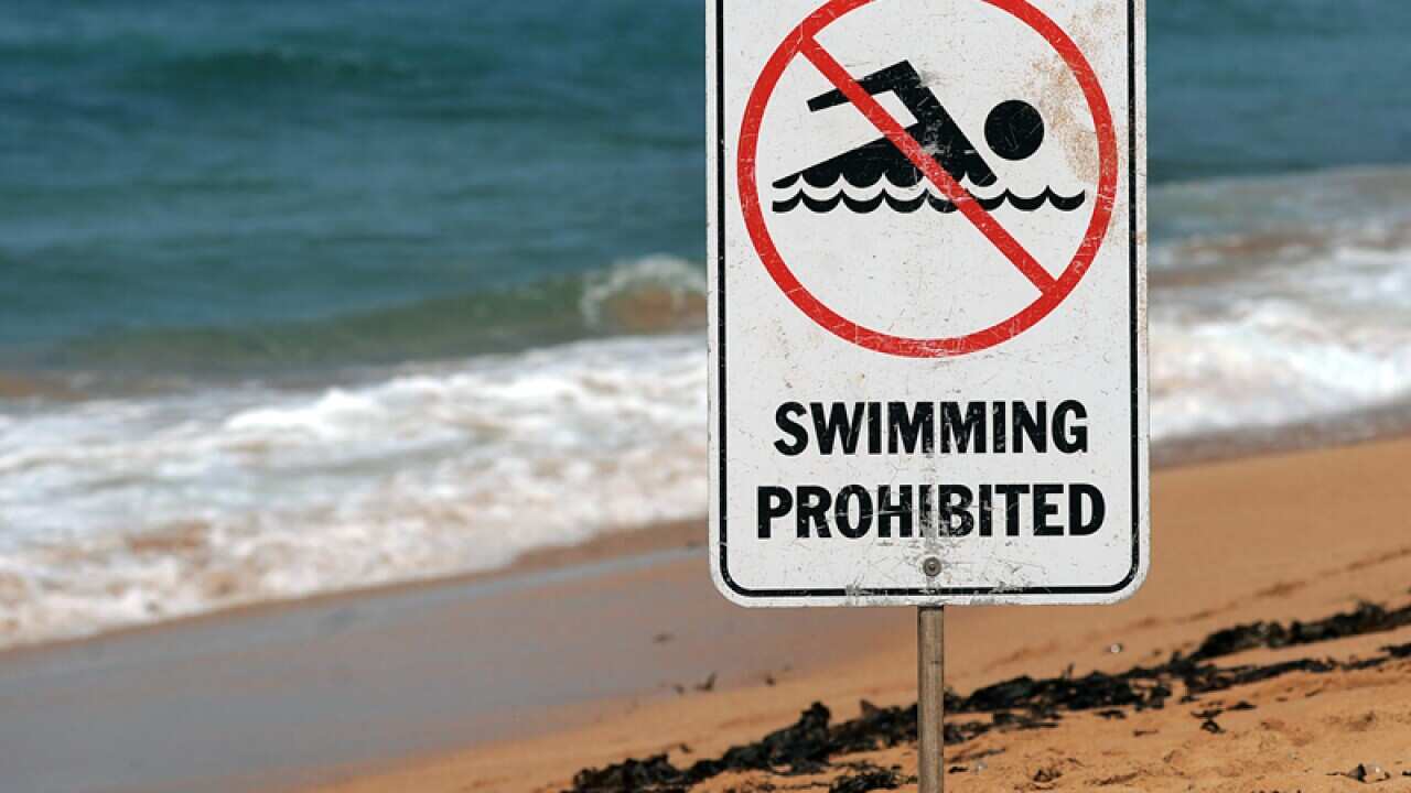 A sign warns swimmers to stay out of the water
