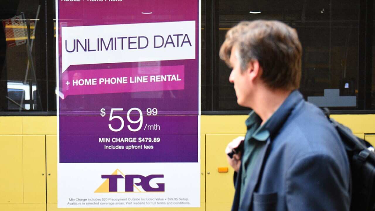 A man was past a bus with a TPG Telecom advertisment in Sydney