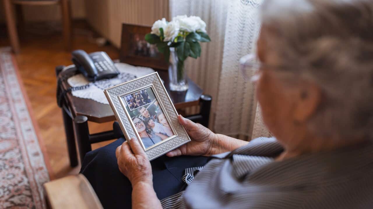 Senior nostalgic woman looking at old photo