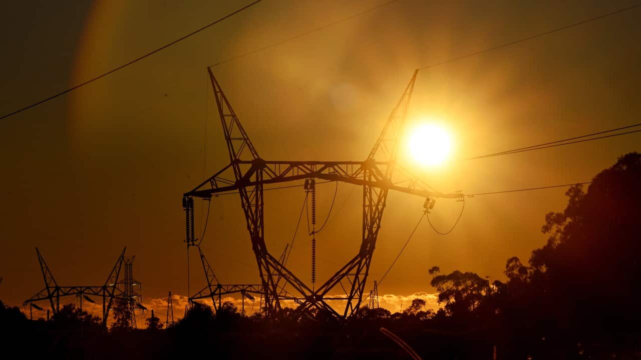 Electricity transmission lines with the sun shining brightly behind