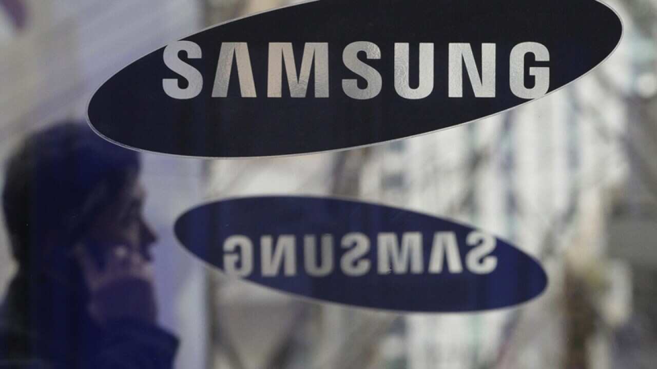 A man passes by the Samsung Electronics Co. logos in Seoul