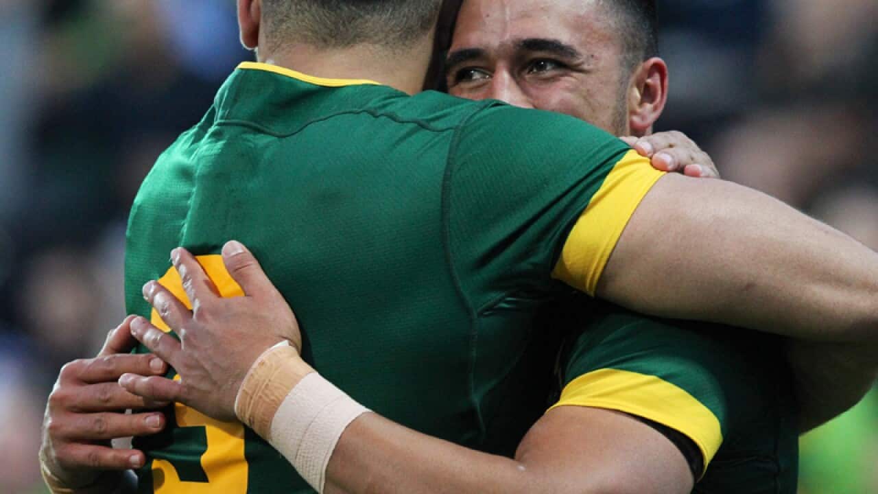 Valentine Holmes for the Kangaroos is congratulated by Greg Inglis