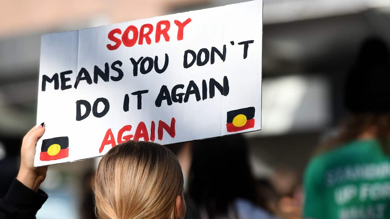 Protestors hold placards as they march through the CBD during a Stop The Stolen Generation! Sorry Day Rally, Sydney, Wednesday, May 26, 2021. (AAP Image/Bianca De Marchi) NO ARCHIVING