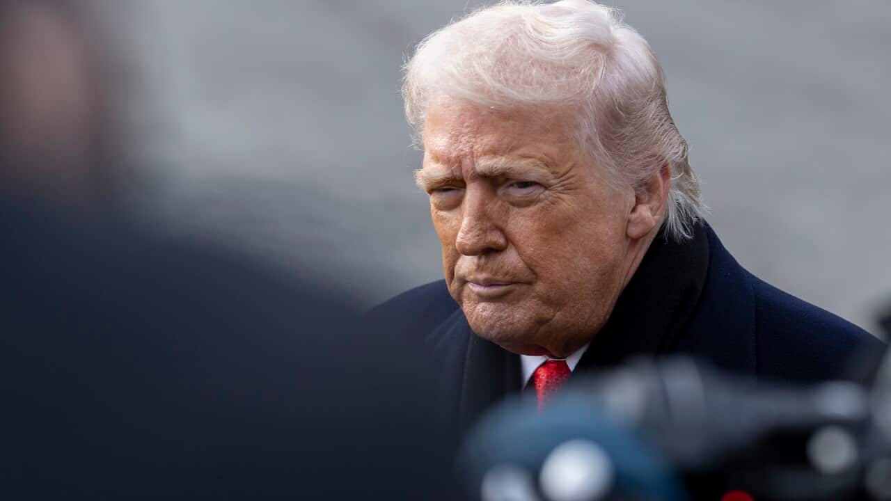 Donald Trump wearing a winter coat and a scarf