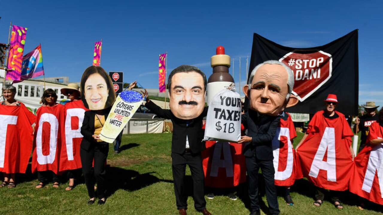 Protesters hold signs and banners at a Stop Adani Mine rally on the lawns of Parliament House in Canberra, Monday, February 5, 2018. (AAP Image/Mick Tsikas) NO ARCHIVING