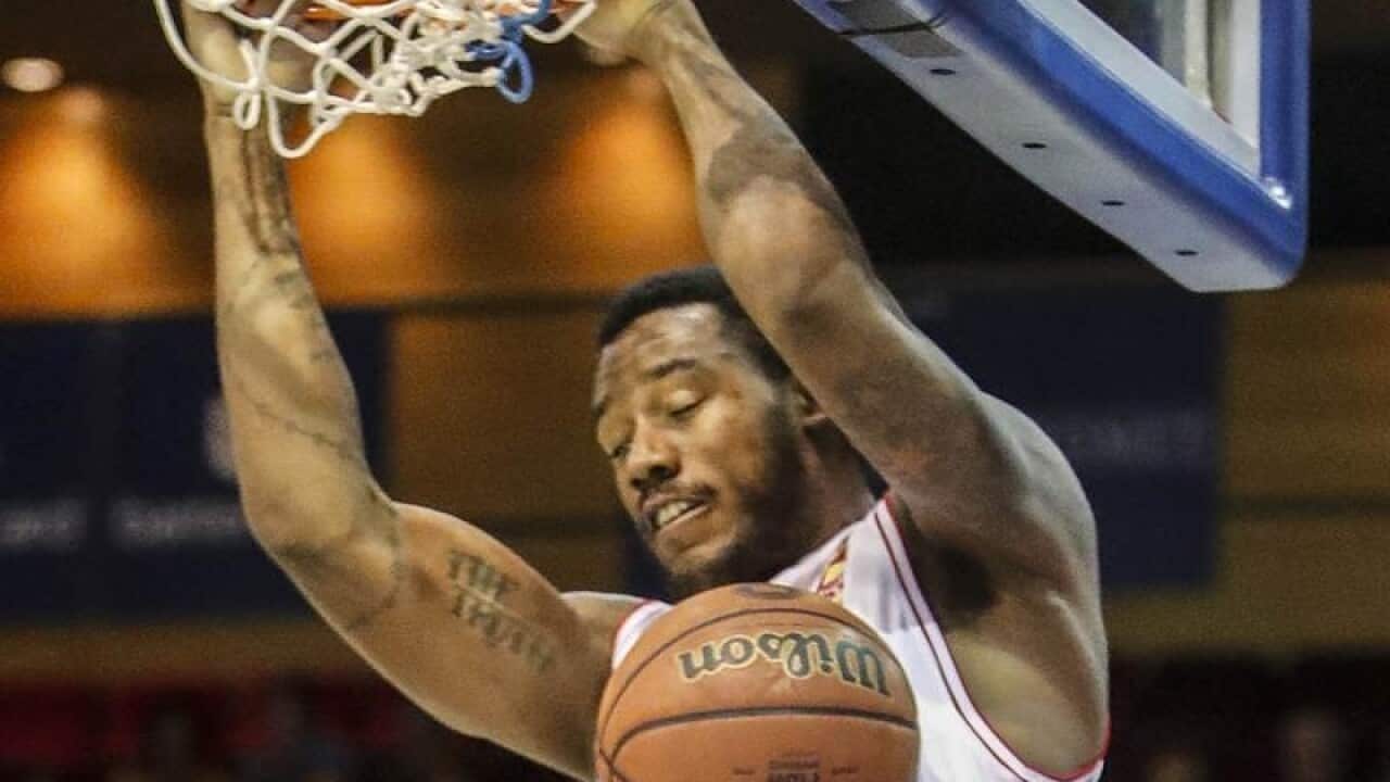 Demetrius Conger of the Hawks hangs off the basket during a game.