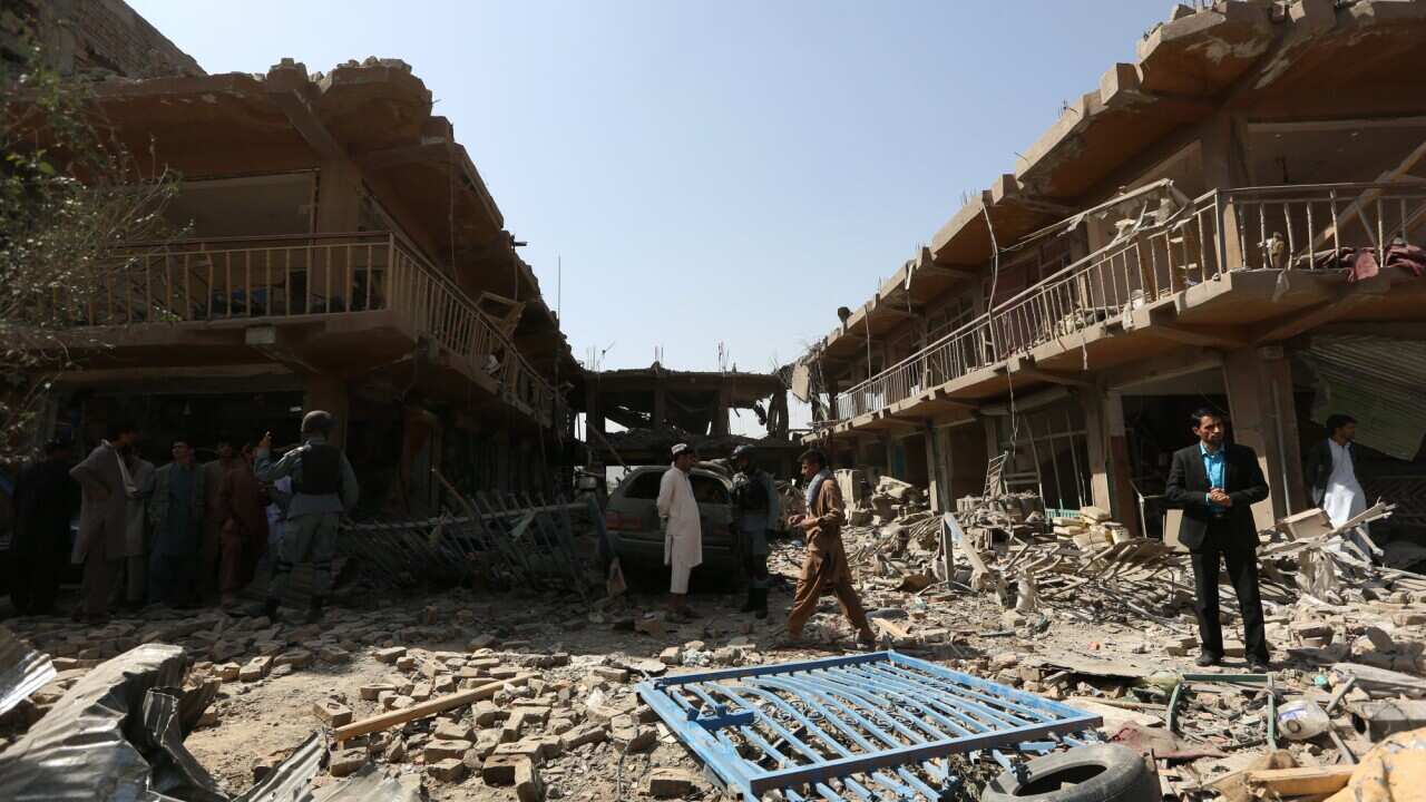 Afghans gather at the site of a car bomb attack in Kabul, Afghanistan