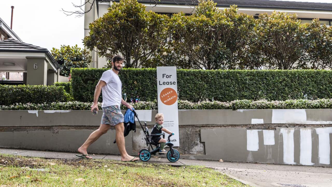 A rental sign in the Sydney suburb of Bondi. A man walks by with a toddler.