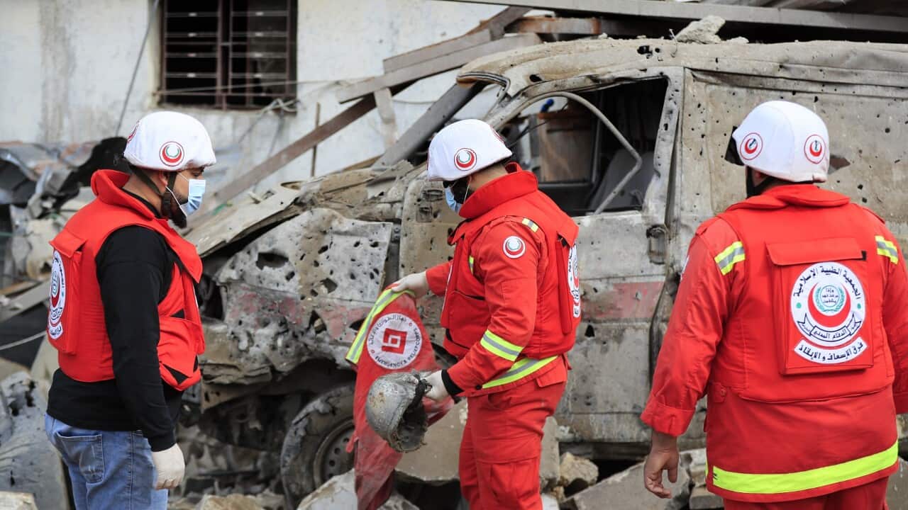 Paramedics collect equipment of their comrades killed at a paramedic centre hit by an Israeli airstrike in Hebbariye village (AAP)
