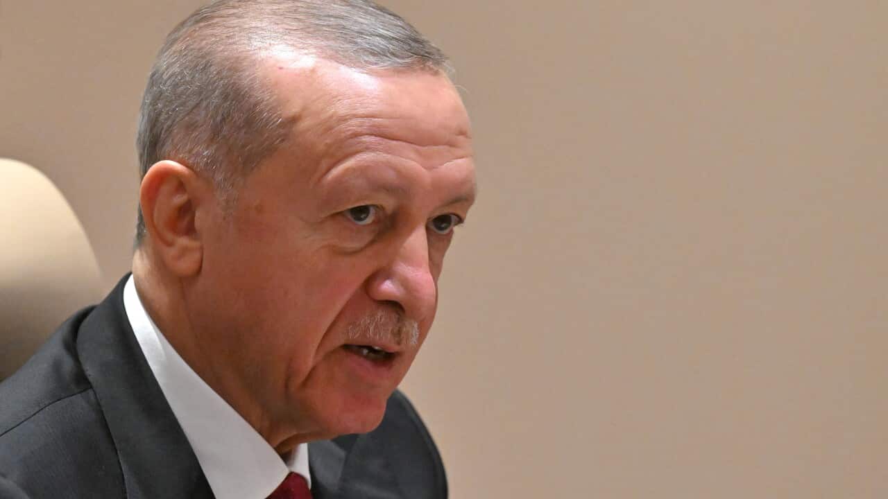 A close-up of Turkish president Recep Tayyip Erdoğan, an older Turkish man with thinnin hair and wearing a suit,