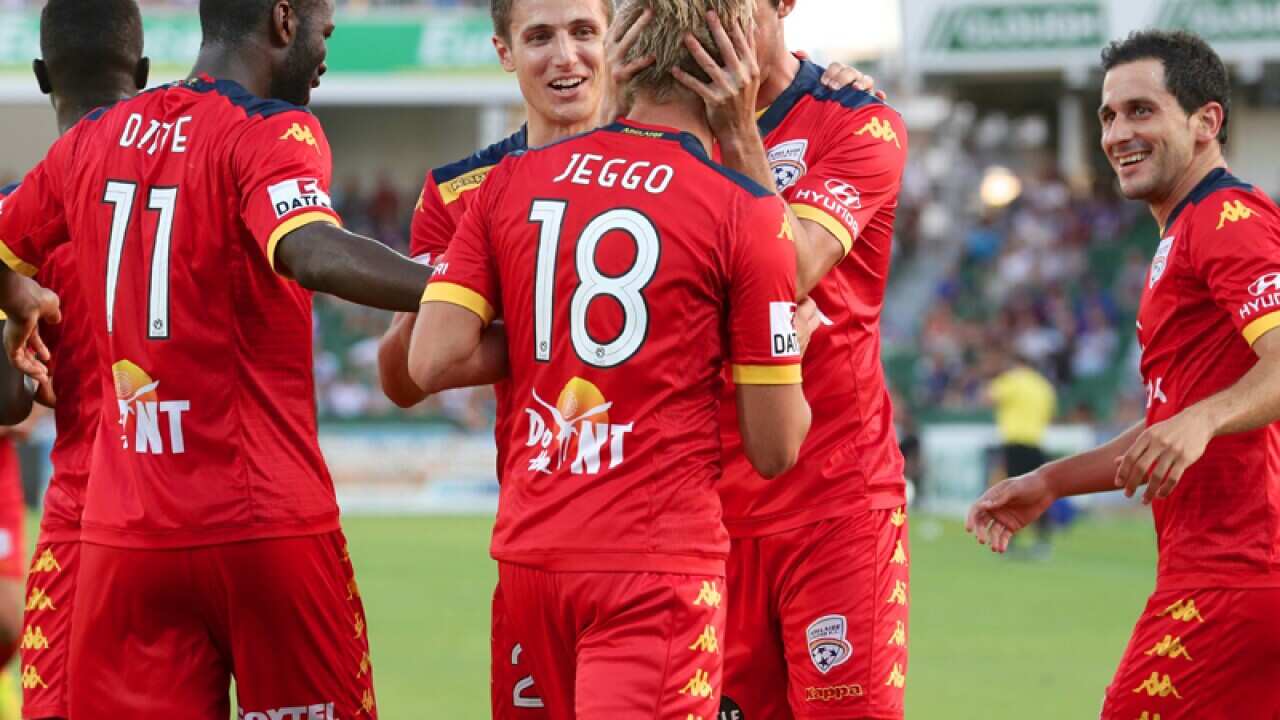 Adelaide United players celebrate after scoring a goal