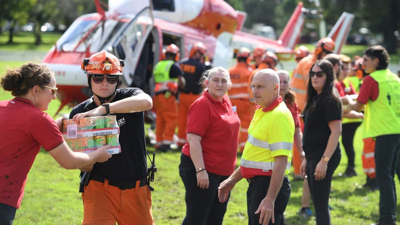 SES volunteers and Coles staff load food and essential items onto a rescue helicopter