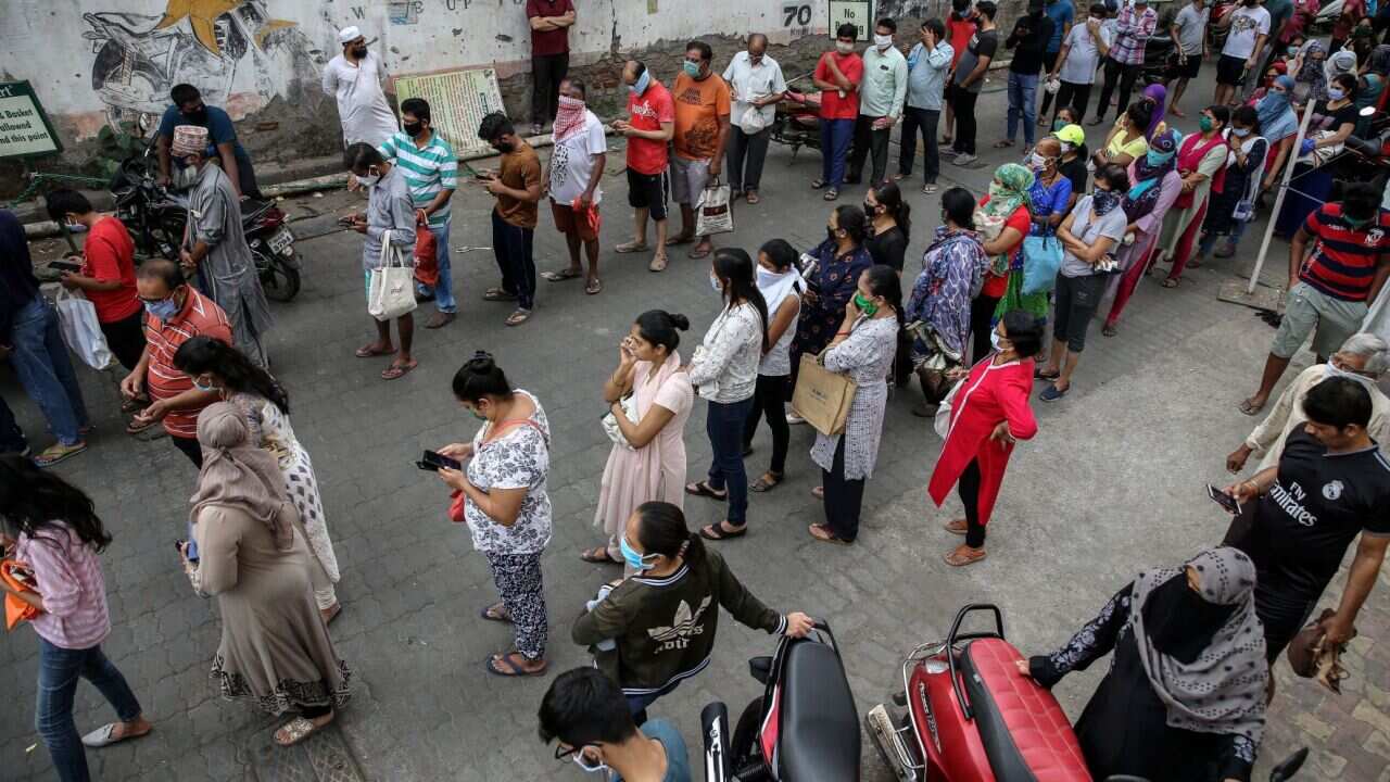 People queue to buy groceries following the Indian lockdown