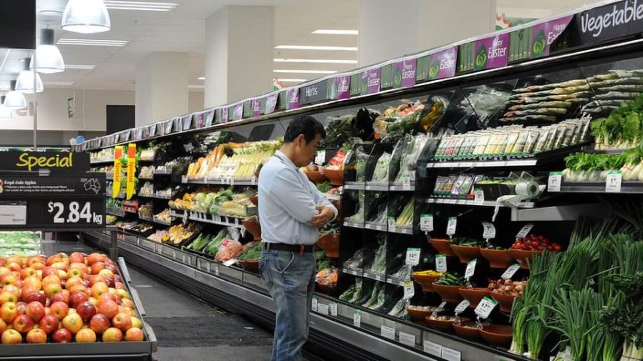 A shopper looks at produce in the fruit and vegetable section inside a Woolworths grocery store in Brisbane, Tuesday, April 19, 2011. (AAP Image/Dave Hunt) NO ARCHIVING