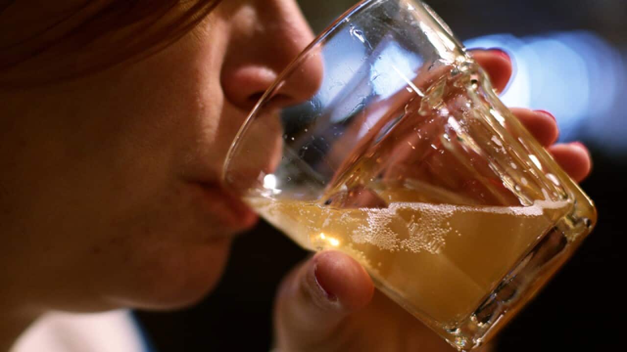 A woman drinking a glass of beer