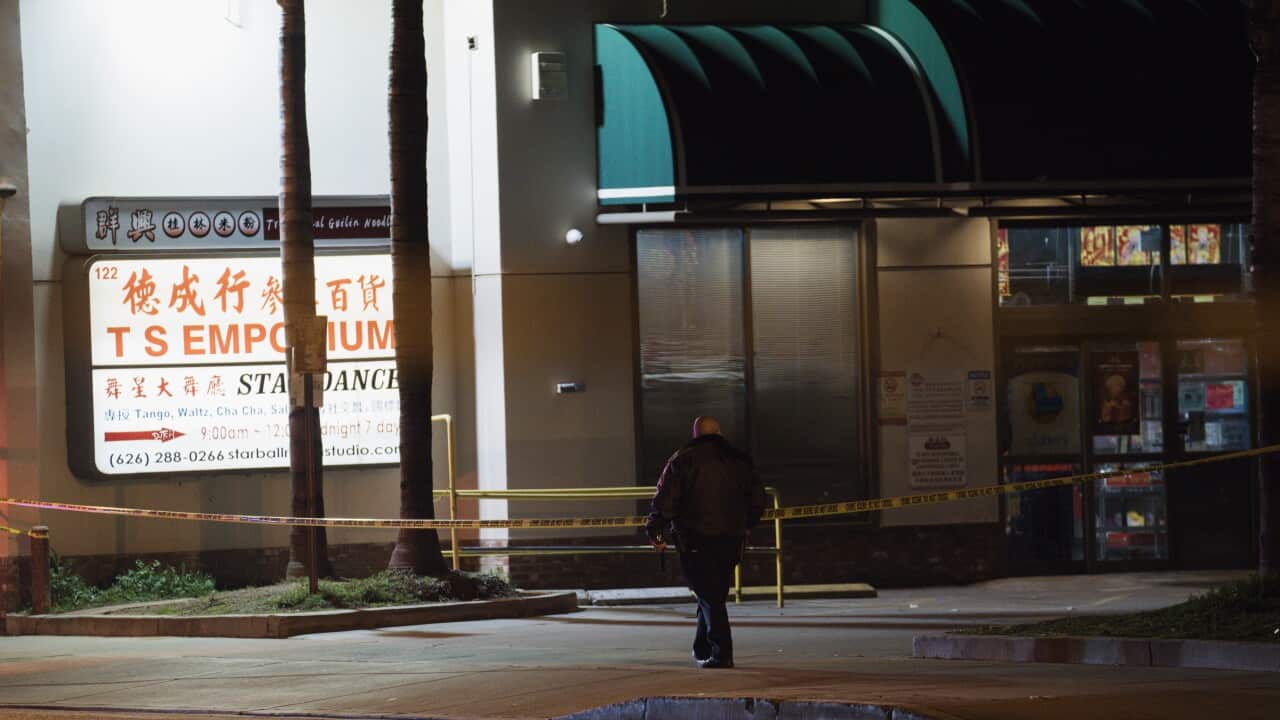 Police officer standing outside dance hall where shooting occurred.