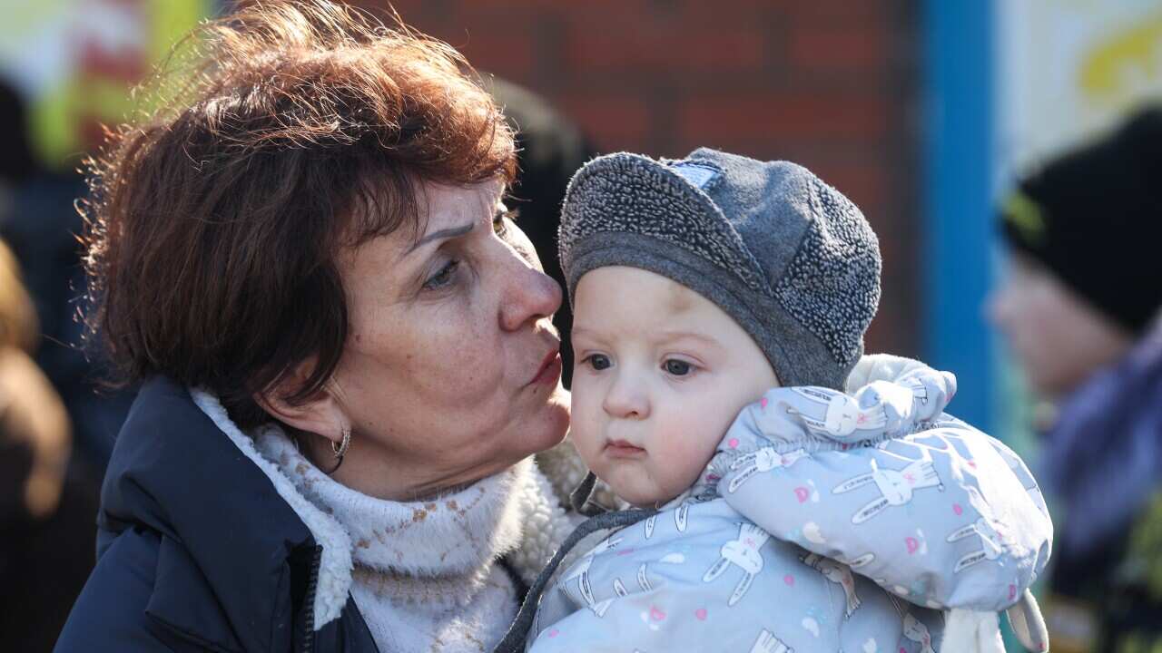 A woman evacuated from Donetsk kisses a child in a tent camp set up by the Russian Emergencies Ministry at the Matveyev Kurgan border checkpoint.