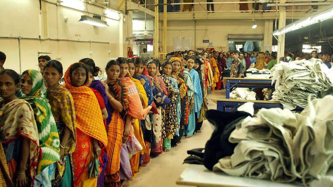 Bangladeshi women workers stand in line for security check