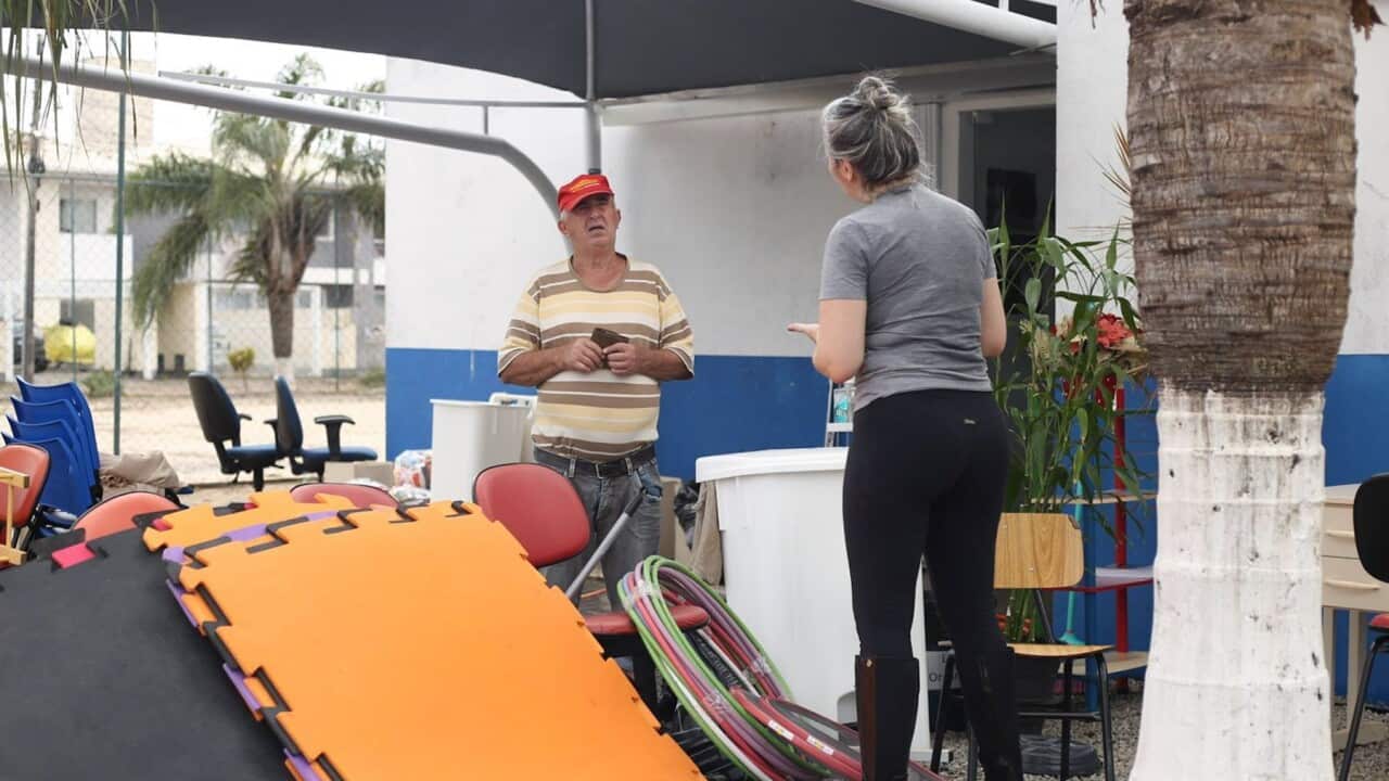 Residents discuss the emergency with their belongings in a pile