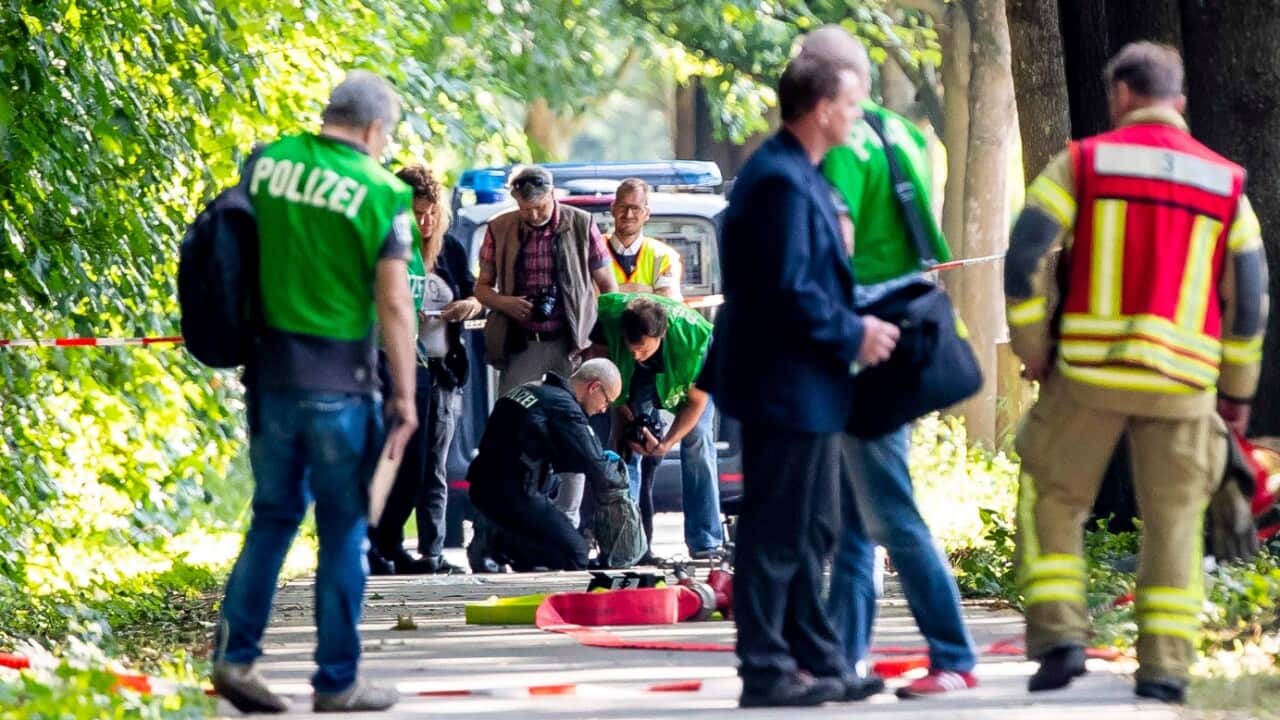 Members of a bomb disposal team check items at the scene where a person had reportedly attacked passengers on a bus in Luebeck, Germany, 20 July 2018. 