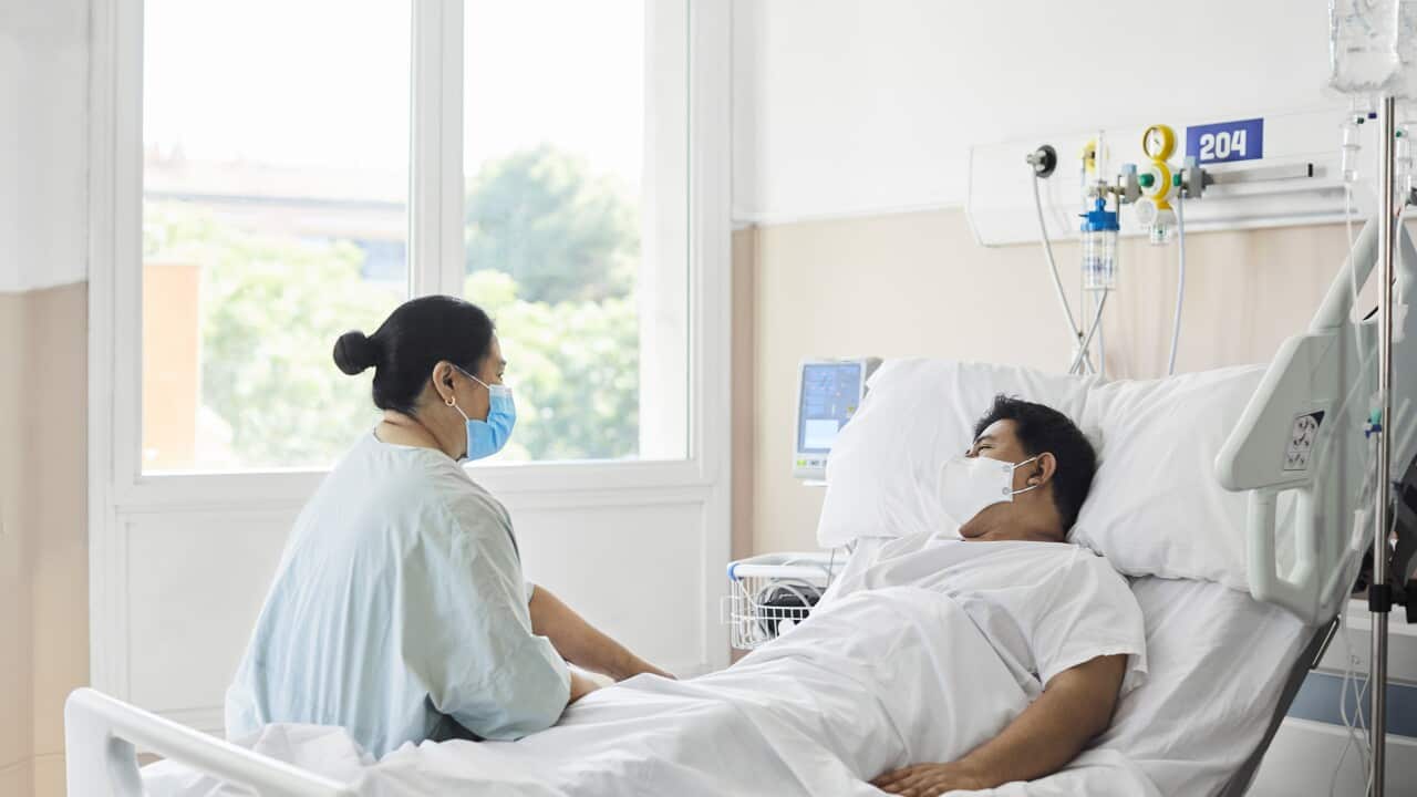 Woman Visiting Male Patient in Hospital Ward