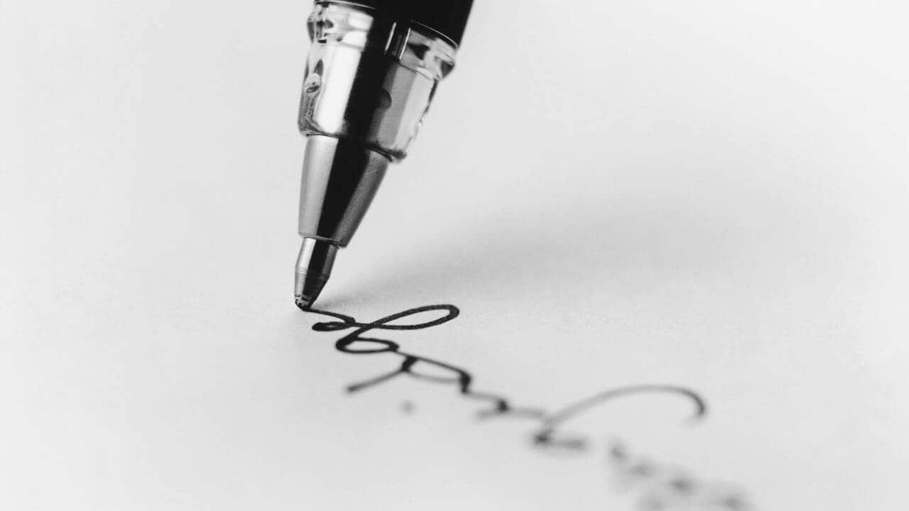 Tip of pen writing on paper.