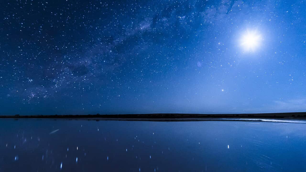 Vivid blue night sky, Milky Way galaxy and Full Moon shining in a starry sky, reflecting over Lake Tyrrell, Australian landscape