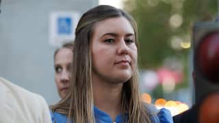 A woman in a blue dress looks on