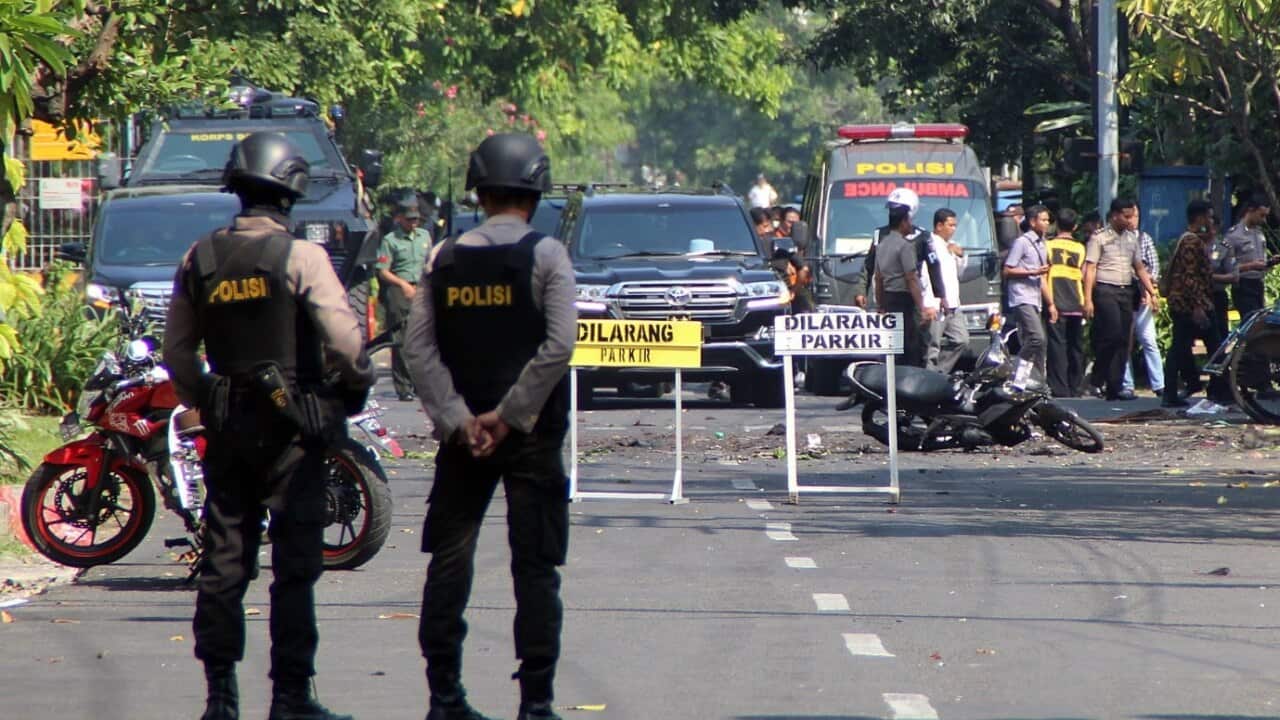 Indonesian bomb squad police officers inspect a blast site in front of a church in Surabaya, East Java, Indonesia, 13 May 2018.
