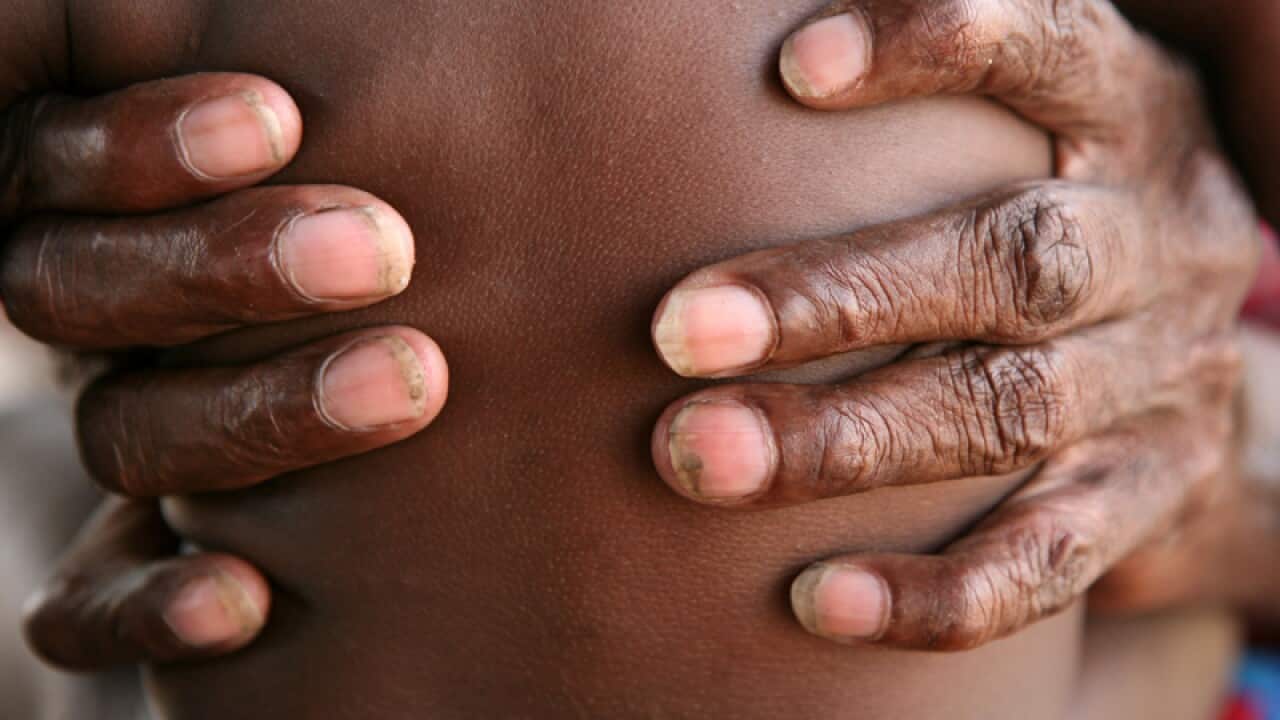A grandmother holds her grand daughter