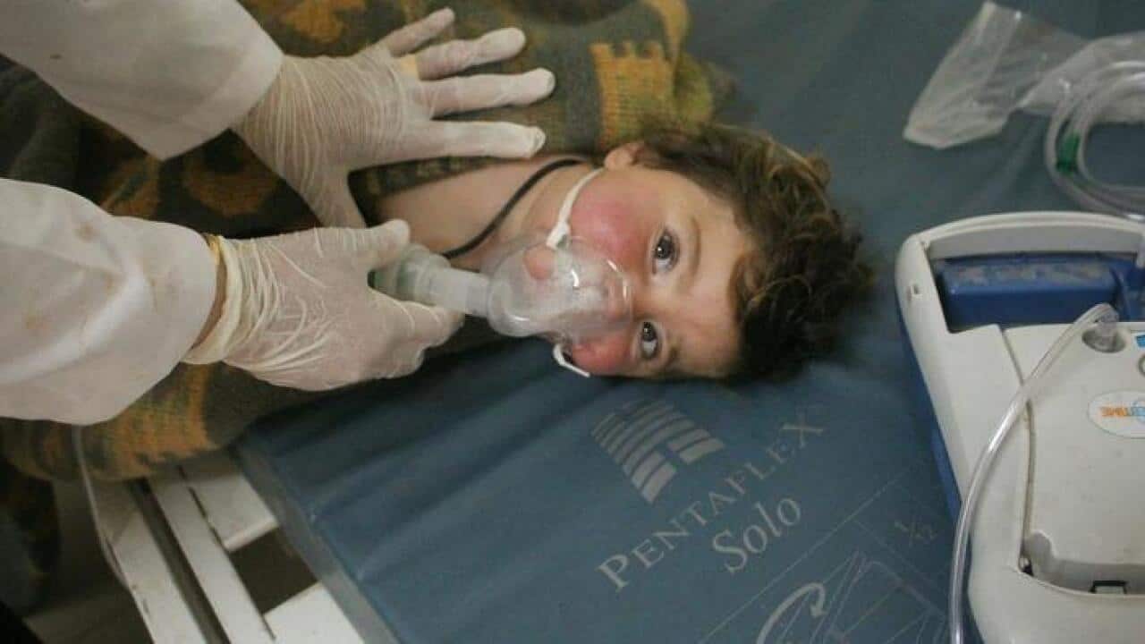 Doctors treating a child following a suspected chemical attack,