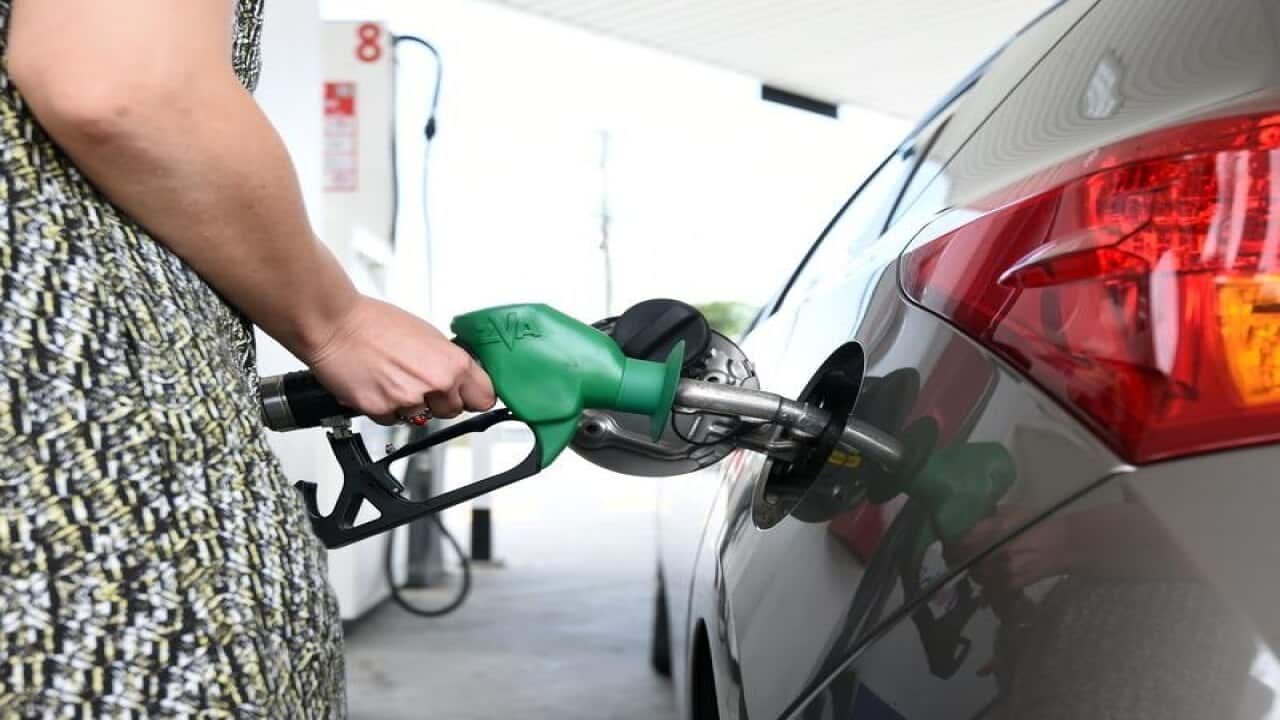 A motorist refuels her car at a service station