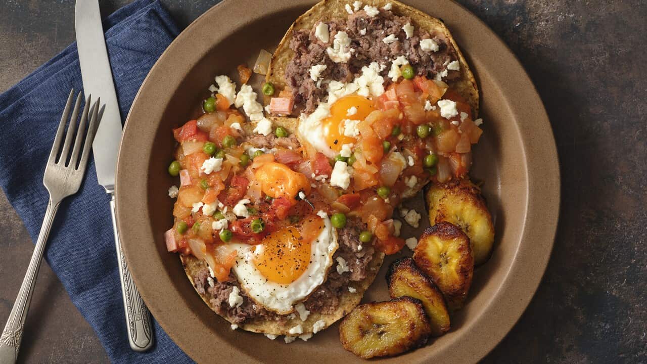 A round plate holds eggs, tortillas, salsa and plaintain slices.