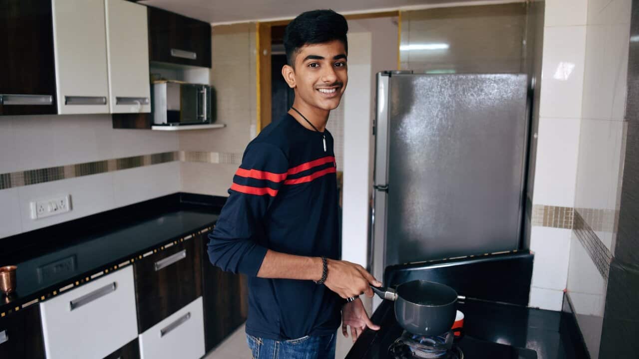 Teenage boy making tea in the kitchen