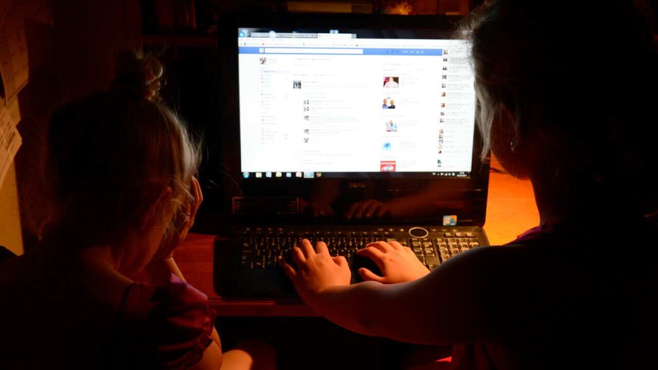 Young girls use a personal computer in Brisbane, Wednesday, Oct. 16, 2013. (AAP Image/Dan Peled) NO ARCHIVING