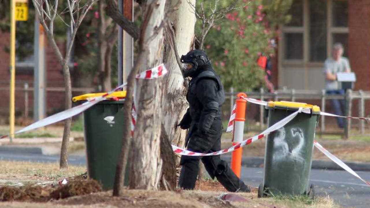A Bomb Squad technician approaches the home.