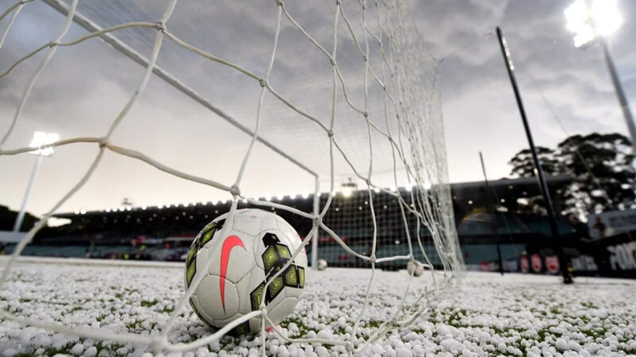 Hail stones cover the pitch following a storm in Sydney