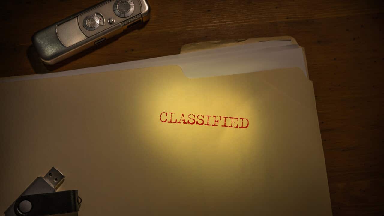Folder marked Classified with spy camera and thumb drive