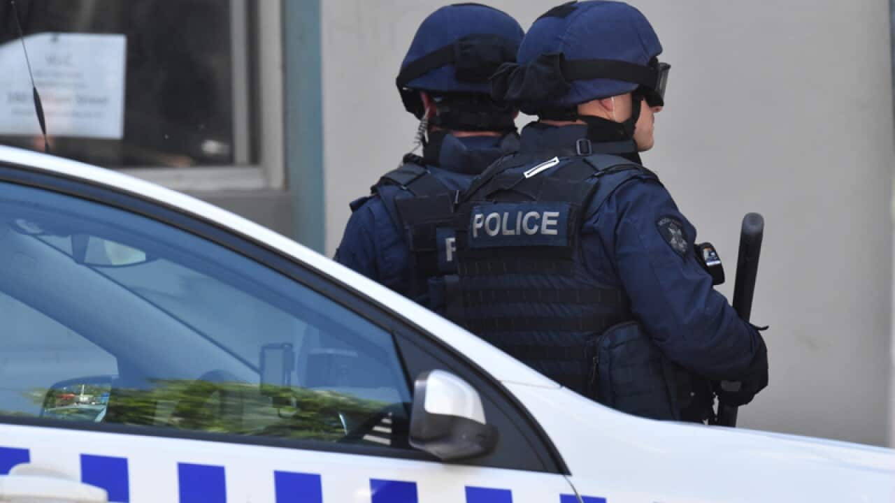Heavily armed police outside a restaurant.